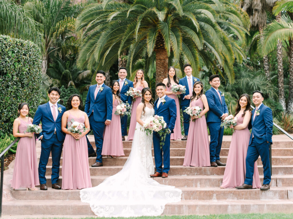 Wedding party on garden steps with lush greenery at Grand Tradition Estate and Gardens.